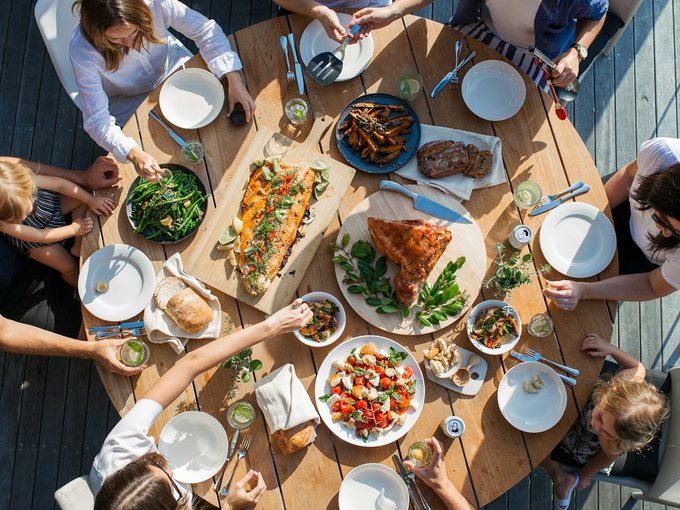 A family sharing dishes around a round table, seen from above